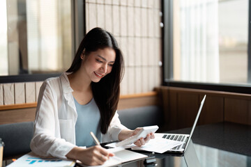Focus and Efficiency. A young woman engaged in detailed financial analysis at her desk.