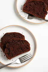 Slices of rich double chocolate pound cake on white plates. Top view