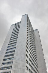 Obraz premium Tall office building against cloudy sky