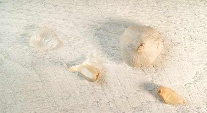 Pealed garlic on rough white board