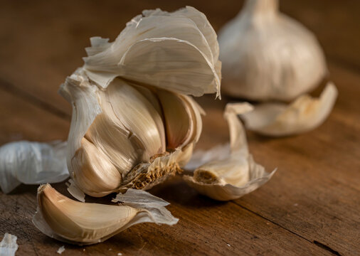Pealed raw garlic on wooden cutting board