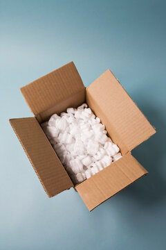 Open cardboard box filled with packing foam peanuts made of expanded polystyrene