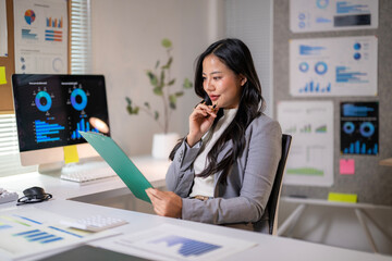 A woman is sitting at a desk with a green clipboard in front of her