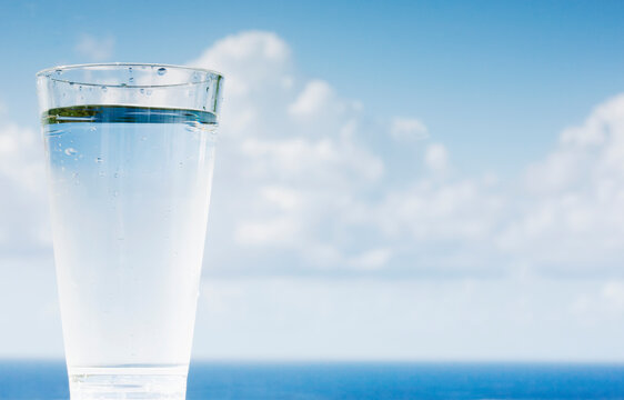Glass of potable water by the ocean
