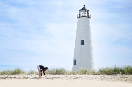 Woman beachcombing by Great Point Light