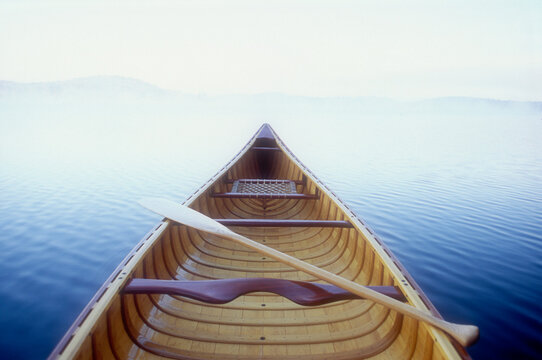 Wood canoe in morning mist on Saranac Lake - Powered by Adobe