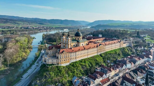 Melk in Lower Austria. Old town with active Benedictine abbey and monastery in Baroque style on the rocky hill and Danube river. Aerial drone 4K video