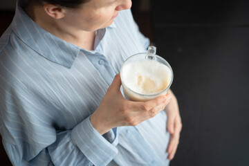 Glowing expecting mother enjoying coffee break at home. Educated perspective on caffeine limits for...