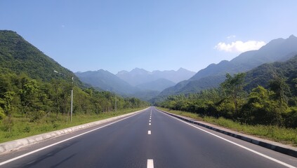 Fototapeta premium a long road leads to the mountains, with green trees on both sides and a blue sky in the background