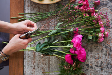 Woman making vibrant, fresh flower bouquet arrangement