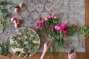 Female hands arranging fresh flower bouquet