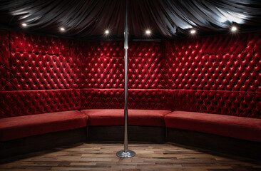 Luxurious Velvet Lounge Interior with Red Upholstered Walls and Center Pole Under Dramatic Lighting
