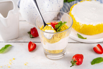 Classic cheesecake in glass, with fresh strawberry and golden cookie crumble