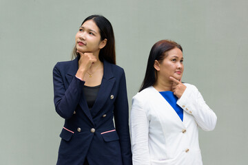 portrait of two businesswomen thinking and looking up