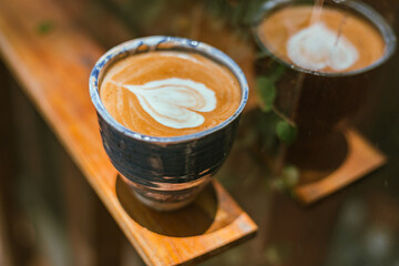  a cup of hot latte art coffee on blur background..
