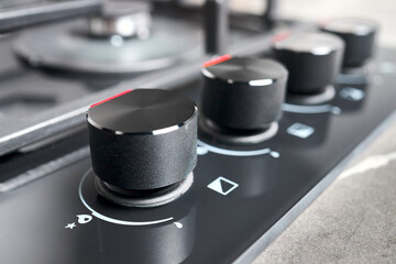 Black and red hob cooker oven grill control knobs selective focus over out of focus oven with...