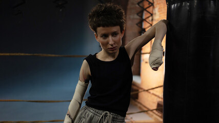 Short-haired fighter in boxing ring, cinematic rest moment between intense rounds.