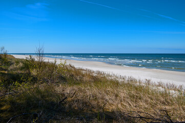Empty beach of the Baltic Sea with white sand, Lubiatowo, Poland. Seascape with waves.