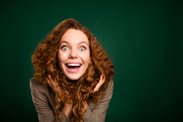 Joyful young woman expressing excitement in stylish formalwear with a vibrant green background