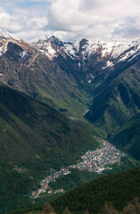 Vertical portrait of the historic village of Premana sprawling up the mountainside, with the imposing Monte Rotondo peak standing sentinel behind, showcasing an iconic Valsassina scene.