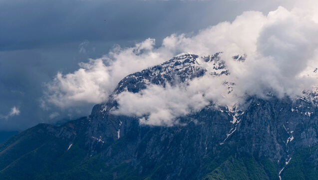 Moody panorama capturing the rugged summits of Grigna Settentrionale and Pizzo della Pieve emerging dramatically from a thick blanket of clouds, highlighting their alpine isolation. Lombardy