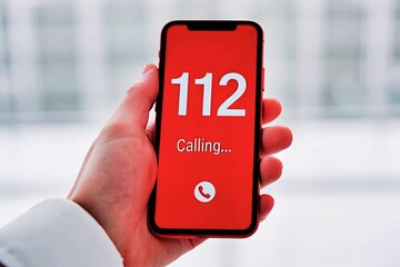 hand holding mobile for call, close up view of of hand holding mobile for emergency call number 112