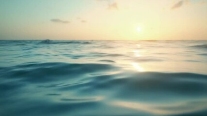 Tranquil ocean sunset scene with calm waves reflecting sunlight. Serene waters at golden hour create peaceful atmosphere. Picturesque coastal view perfect for relaxation video background.