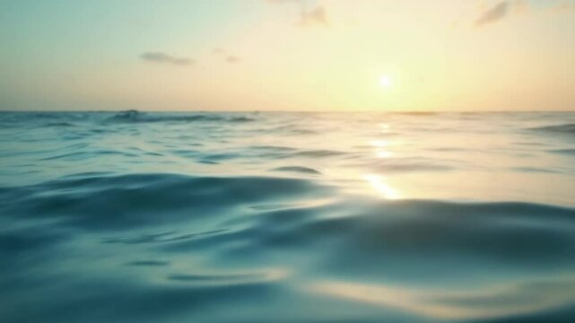 Tranquil ocean sunset scene with calm waves reflecting sunlight. Serene waters at golden hour create peaceful atmosphere. Picturesque coastal view perfect for relaxation video background.