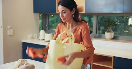 Grocery bags, unpacking vegetables and woman in kitchen for cooking dinner with organic cucumber. Groceries, shopper and unloading food in home, natural ingredients and fresh carrots for healthy diet - Powered by Adobe