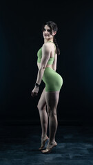 Obraz premium Confident fitness model posing on black background showing muscles 
