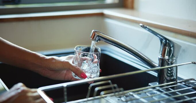 Hands, tap water or woman with glass, thirsty or kitchen with wellness, hydration or sink. Closeup, home or person with open faucet, filtration system or fresh beverage with healthy skin detox or cup