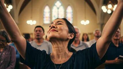 Woman praising at church with other people and stained glass window
