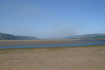a view of the river Dovey from ynyslas beach with the smoke from a wild fire close to Machynlleth in the background 