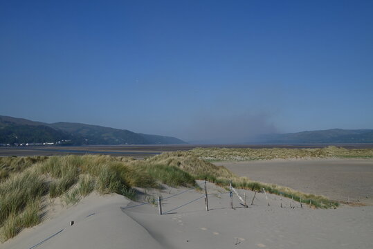 a view of the river Dovey from ynyslas beach with the smoke from a wild fire close to Machynlleth in the background 