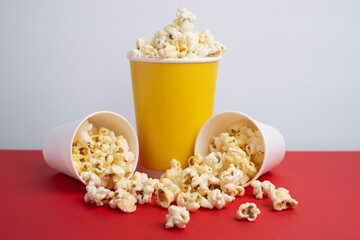 Delicious popcorn in a bucket on a red background. Tasty snack