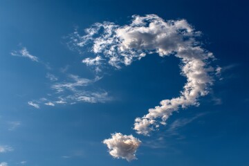 Unique cloud formation resembling a question mark against a clear blue sky during the afternoon