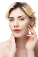 Fototapeta premium A young blonde girl with clear skin in a satin top. Beauty portrait of a woman on a white background in the studio.