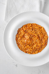 Creamy tomato risotto on clean white plate