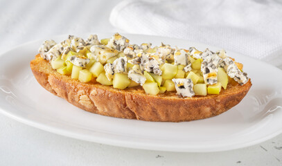 Toasted sandwich with blue cheese, honeyed sauteed apple on minimalist white plate