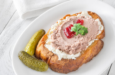 Gourmet sandwich layered with pate, cranberry jam, and cream cheese