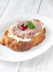 Gourmet sandwich layered with pate, cranberry jam, and cream cheese