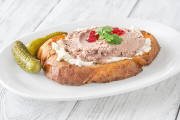 Gourmet sandwich layered with pate, cranberry jam, and cream cheese