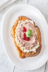 Gourmet sandwich layered with pate, cranberry jam, and cream cheese