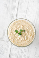Creamy blue cheese sauce garnished with thyme in clear bowl on table