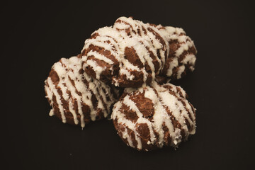 Profiteroles with coconut cream on a black background.