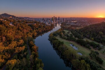 City skyline reflects in river during sunset over Brisbane providing a scenic view of nature and urban landscape