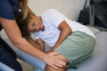 Obraz premium Close-up of therapist aiding young patient during a stretching exercise