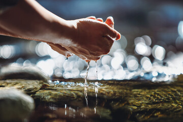 Drink the clear and clean water of the clean stream in your hand, the precious water of life, World Water Day background
