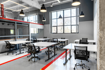 Modern coworking space featuring bright, spacious desks and ergonomic chairs in an urban setting