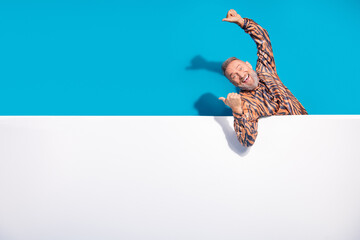 Charismatic Mature Gentleman Celebrating Enthusiastically Against a Bold Blue Background